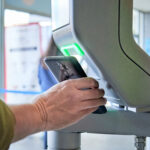 person scanning smartphone on a security control pass machine to entrer in a secured area