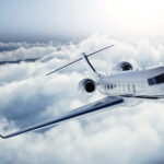 Business jet flying above the clouds