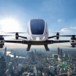 Autonomous driverless aerial UAM vehicle flying on city background